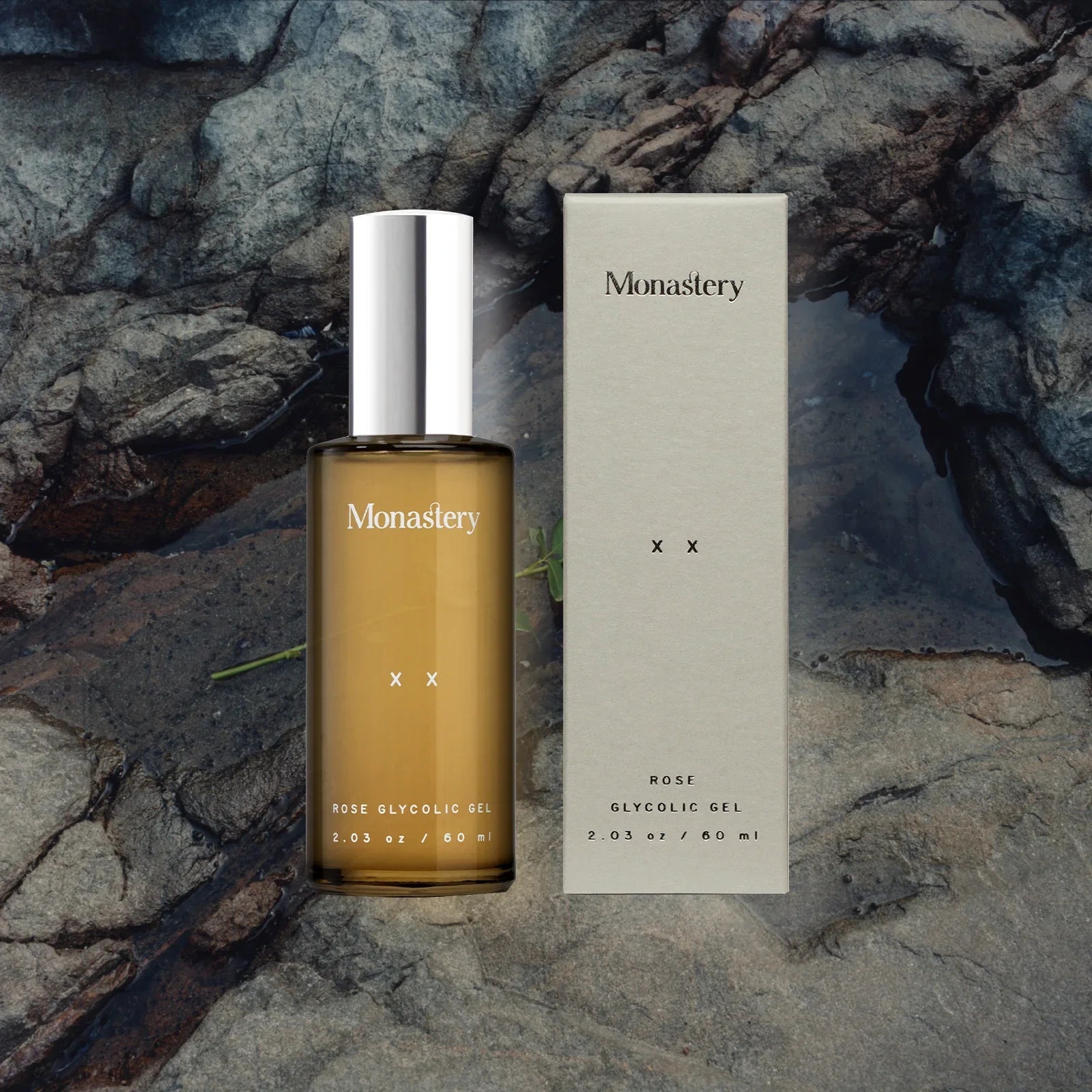 Monaster Rose Glycolic Gel Flasche und Verpackung vor Felsen.