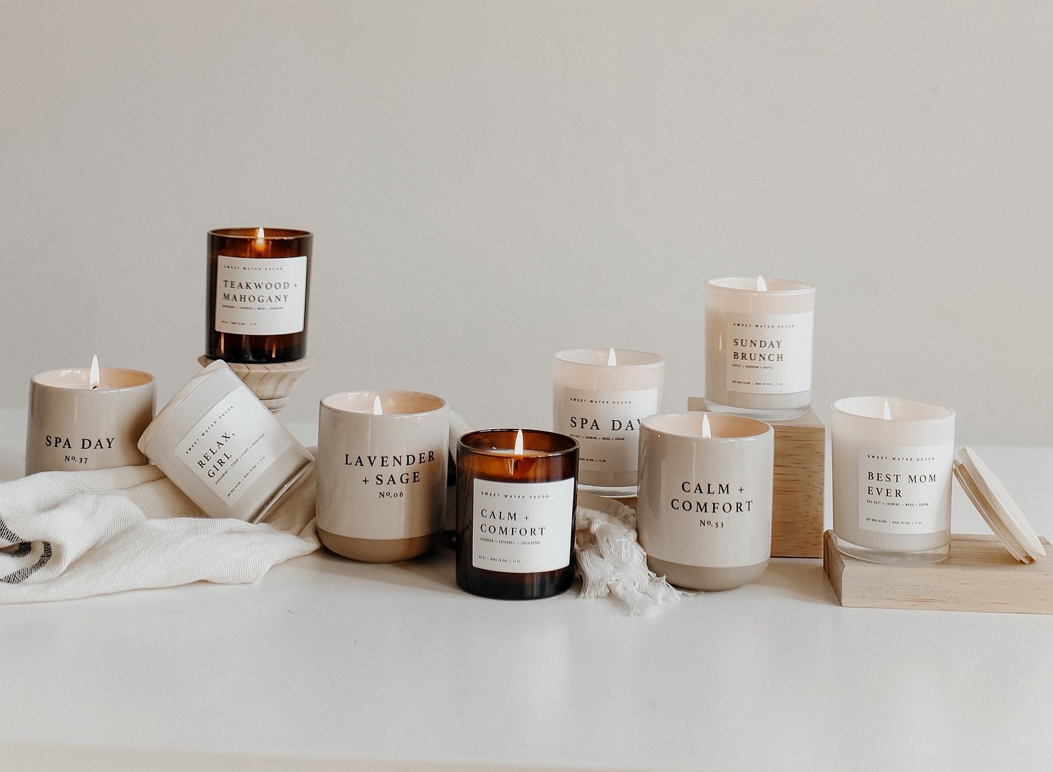 Verschiedene brennende Duftkerzen im Glas oder Steingutbecher - Sweet Water Deco