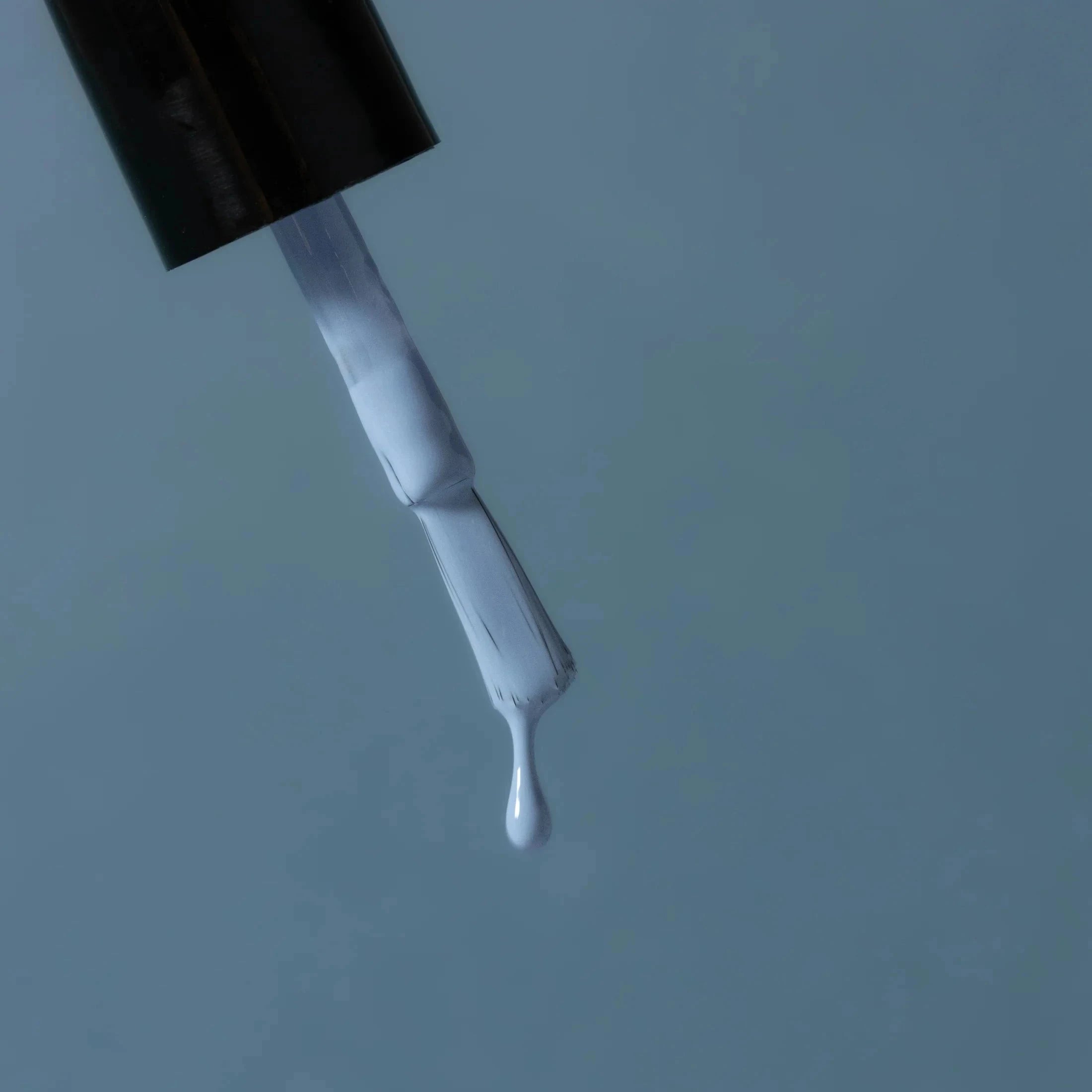 Nagellack Bleu Cotton 34 von Karolin Van Loon, vom Pinsel tropft Nagellack.