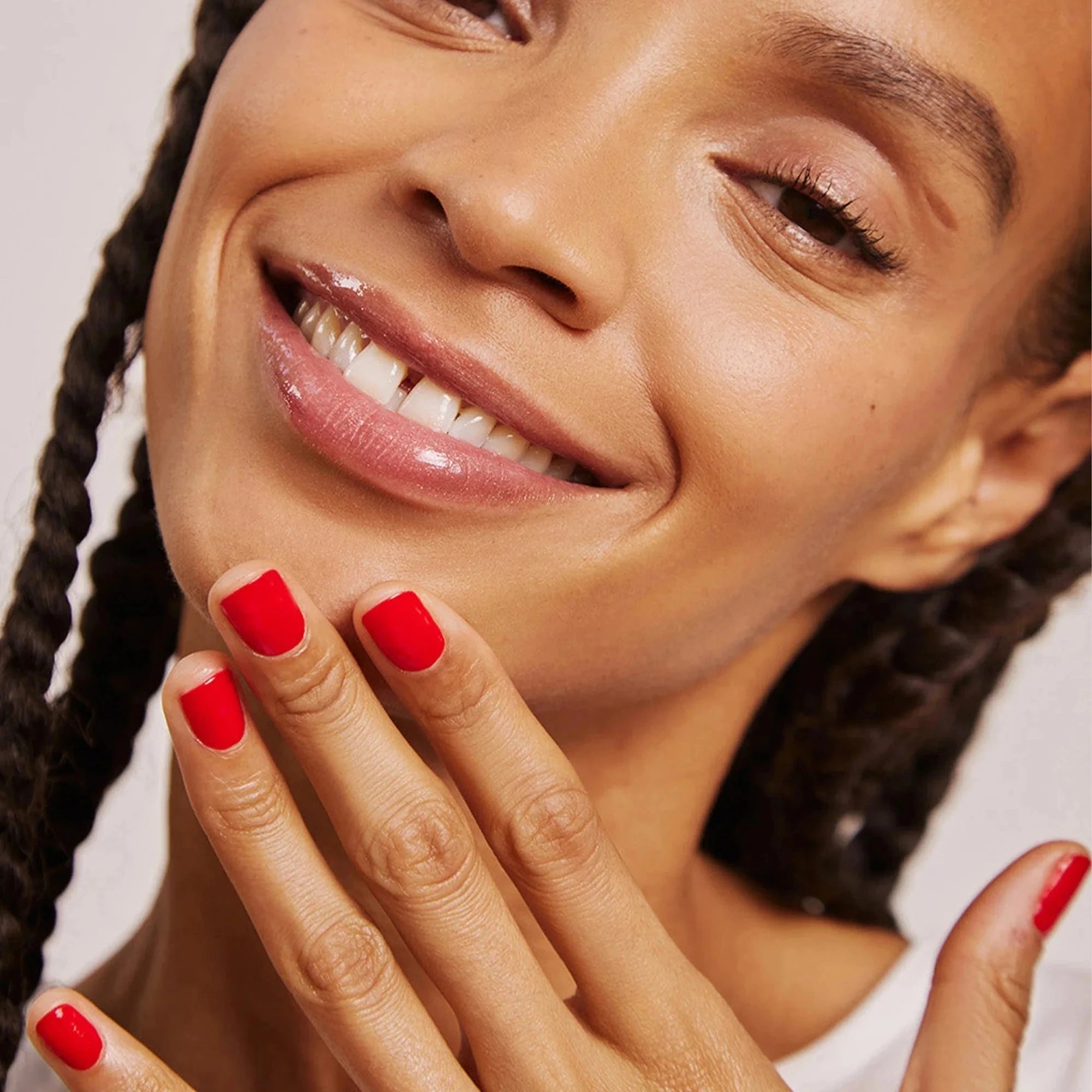 Frau hält ihre Hand mit Nagellack 37 Tomate Rouge von Karlin van Loon vors Kinn.