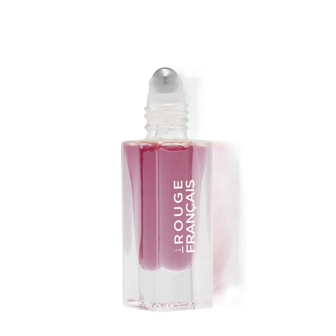 Offene Le Rouge Francais Le Nectar Lippenöl Glasflasche mit Applikatorkugel vor weißem Hintergrund. North Glow