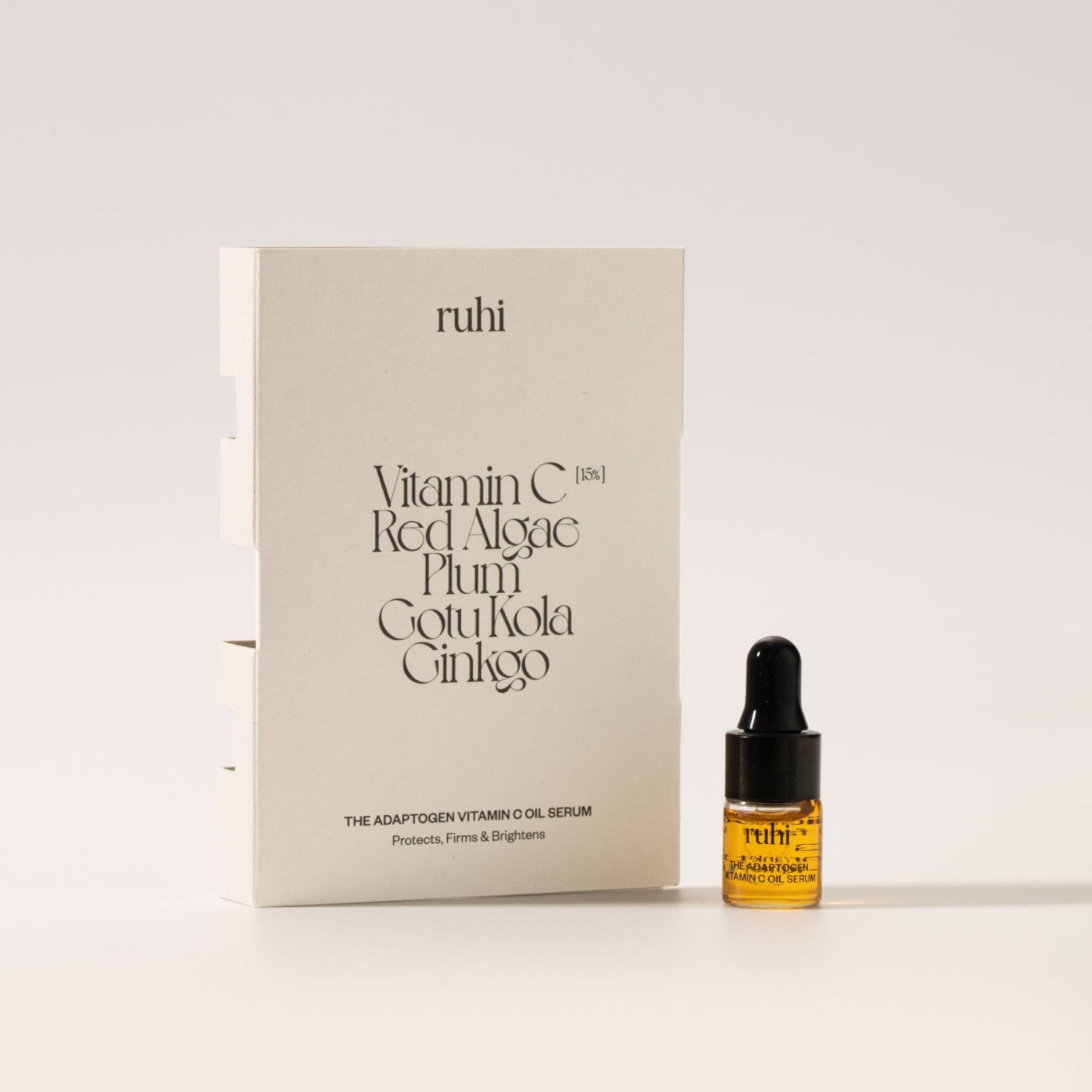 ruhi The Adaptogen Vitamin C Oil Serum in der kleinen 2ml Probegröße (Sample-Fläschchen) mit Pipette neben der minimalistischen, beigen Verpackung.
