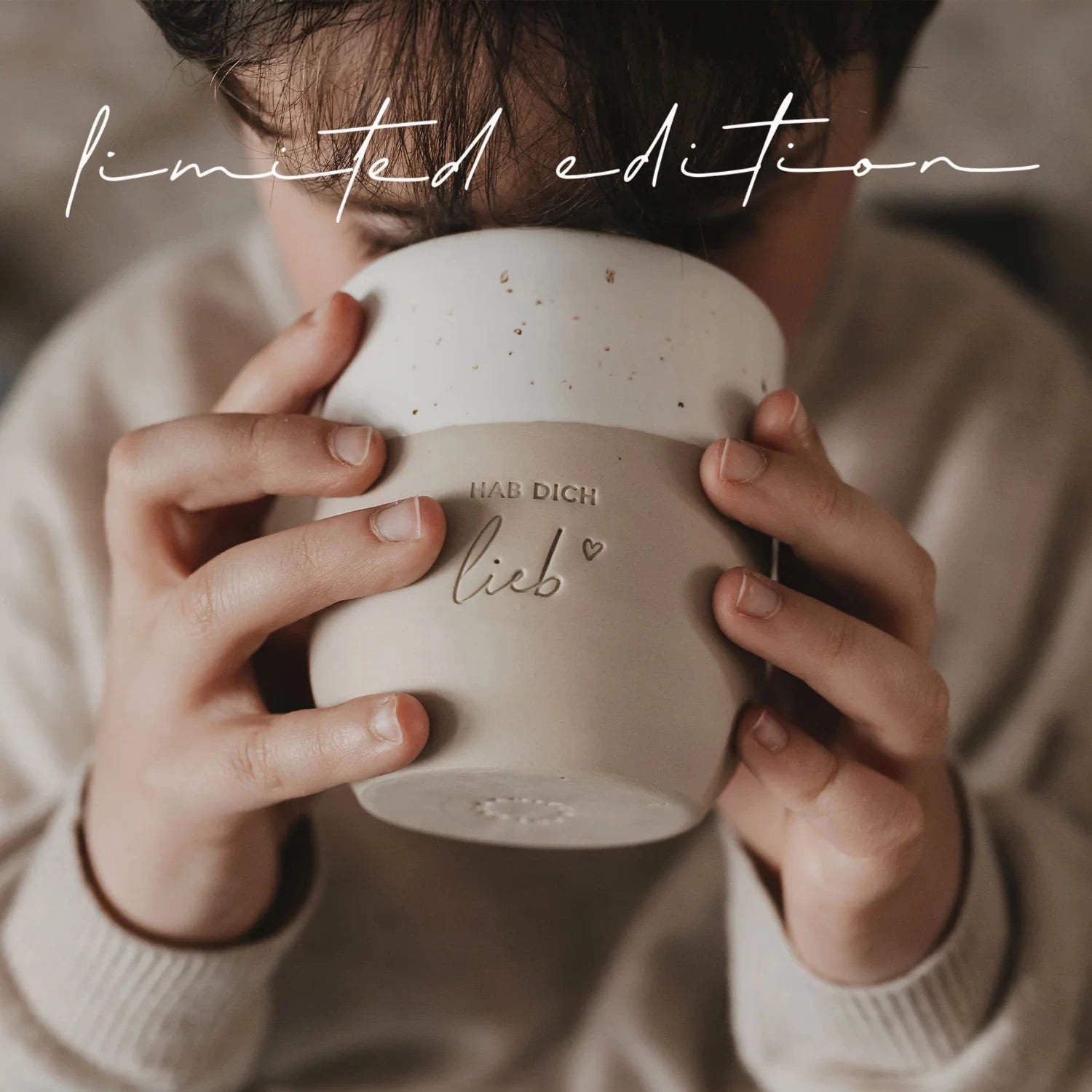 Becher "Hab dich lieb" von Eulenschnitt wird in zwei Händen gehalten und zum Mund geführt, um daraus zu trinken.