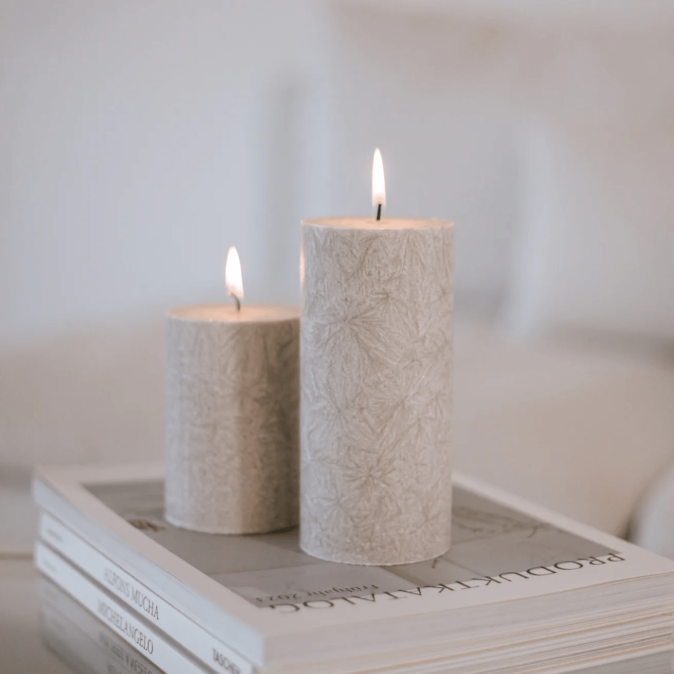 2 verschieden große Blockkerzen Olive von Eulenschnitt in Grau stehen auf Produktkatalogen.