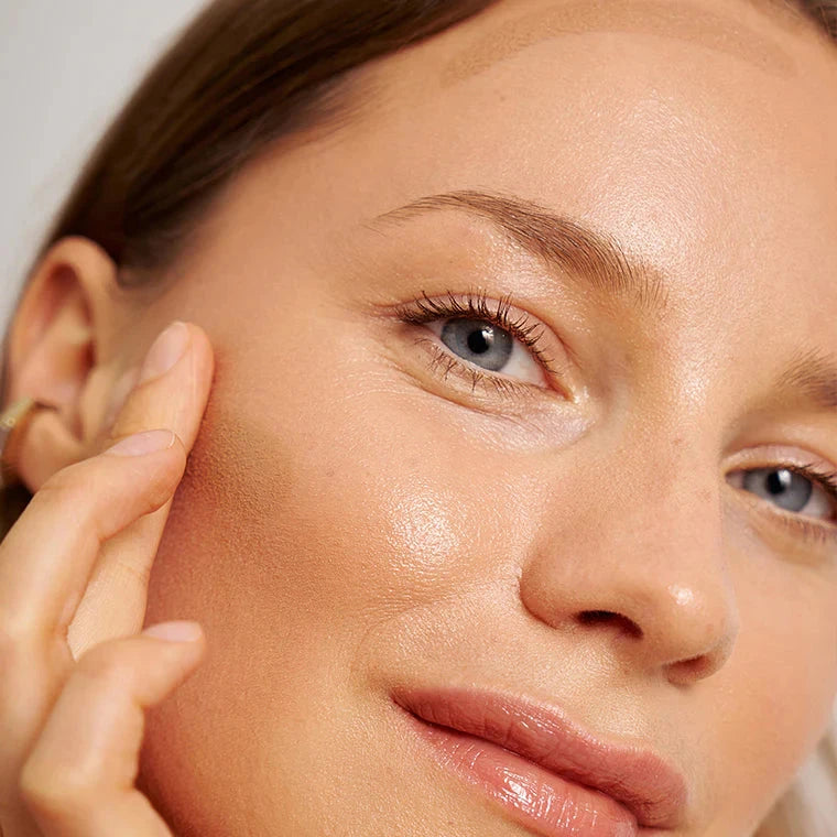 Gesicht einer Frau, die mit einem Finger den Bronzing Balm von PURE U. Cosmetics verblendet.