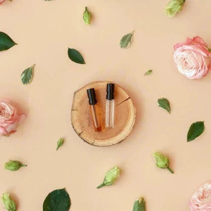 Duftproben auf Holzplatte mit Rosenblüten drum herum