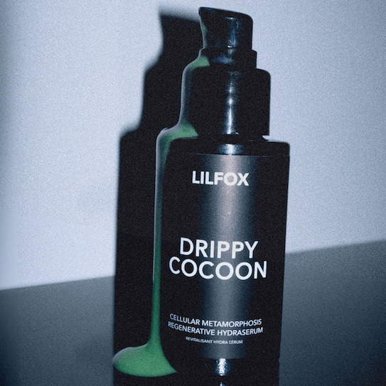 Aus der schwarzen Glasflasche fließt hellgrünes Serumkonzentrat - Lilfox Drippy Cocoon.