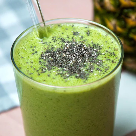 Halbes Glas mit grünem Smoothie Shake und Chia Samen