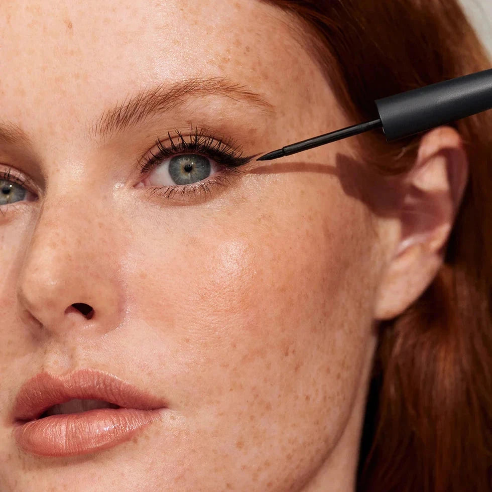 Eine Frau trägt den Liquid Eyeliner auf.