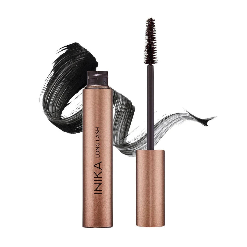 INIKA Long Lash Mascara geöffnet, , im Hintergrund ein Mascara-Farbstreifen.