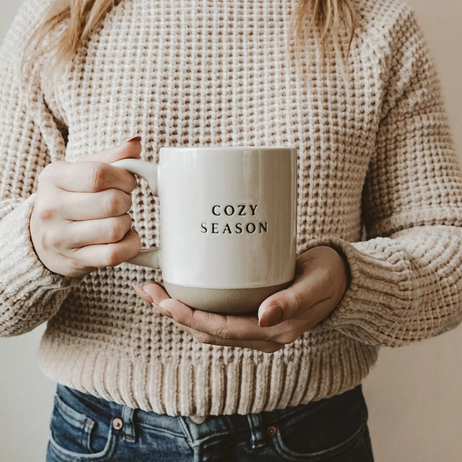 Zwei Hände halten die Kaffeetasse Cozy Season von Sweet Water Decor.