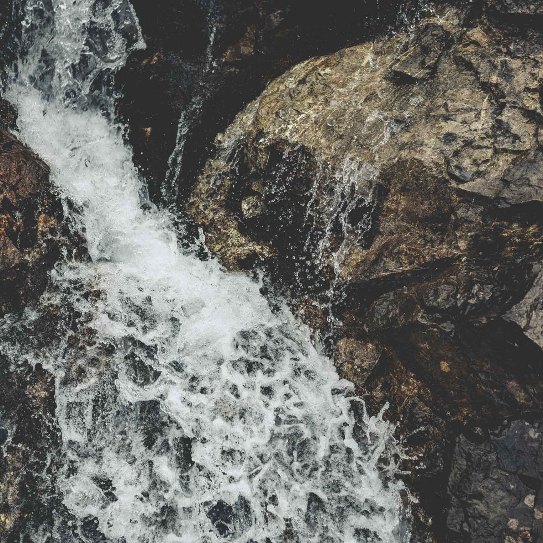 Bild von einem Gebirgsbach aus der Vogelperspektive.
