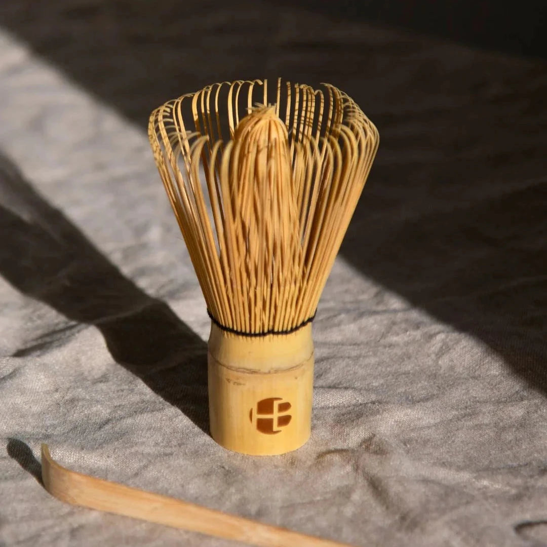 Matcha Besen (Chasen) stehend auf grauer Tischdecke.