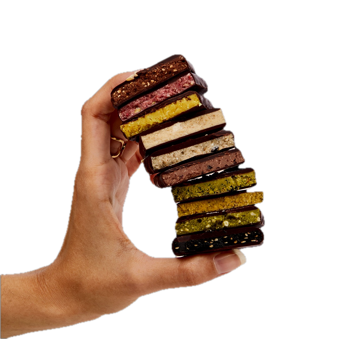 Eine Hand hält einen Stapel durchgebrochener Schokoladentäfelchen von Cosmic Dealer in verschiedenen Geschmacksrichtungen.