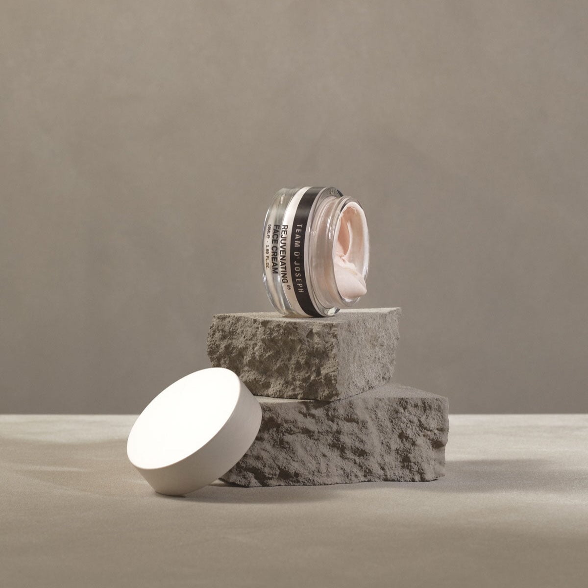 Team Dr Joseph Rejuvenating Face Cream im offenen Glastiegel – stilvoll präsentiert auf einer Naturstein-Oberfläche