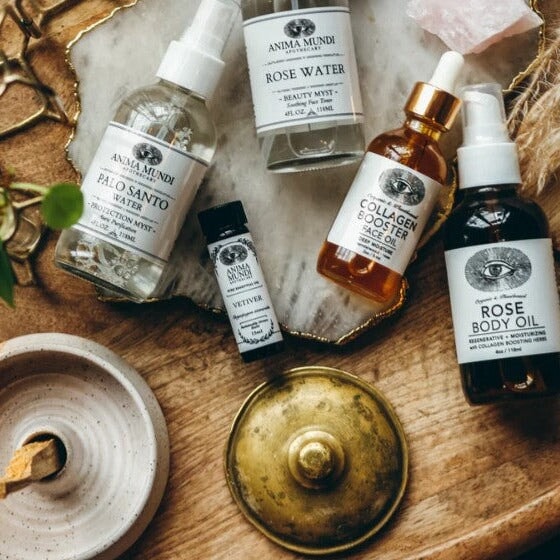 Anima Mundi Rose Water Flasche mit anderen Anima Mundi Produkten liegend auf einem Holztisch