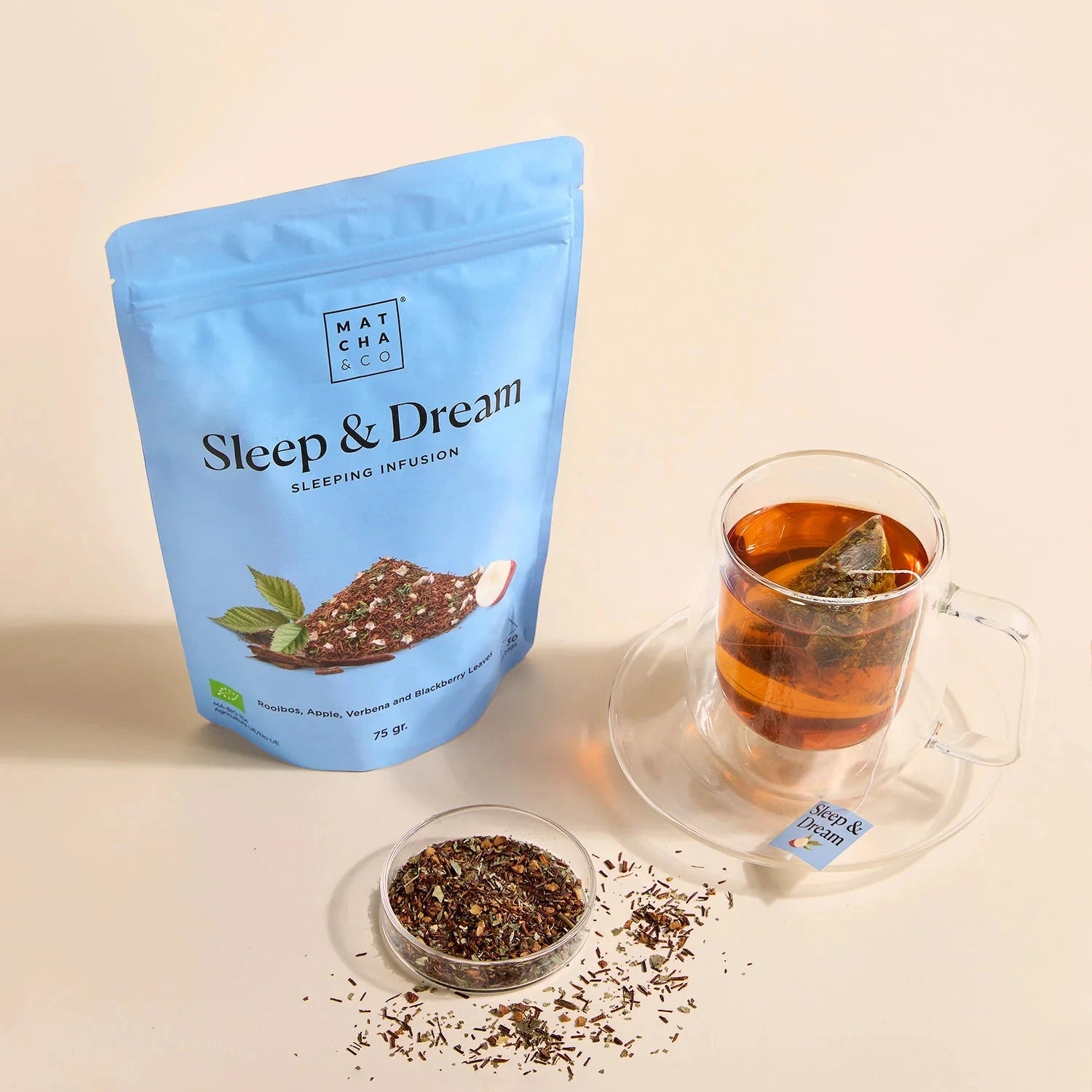 Sleep & Dream Kräutertee, daneben eine Tasse mit frischem Tee und loser Tee in einer Schale.