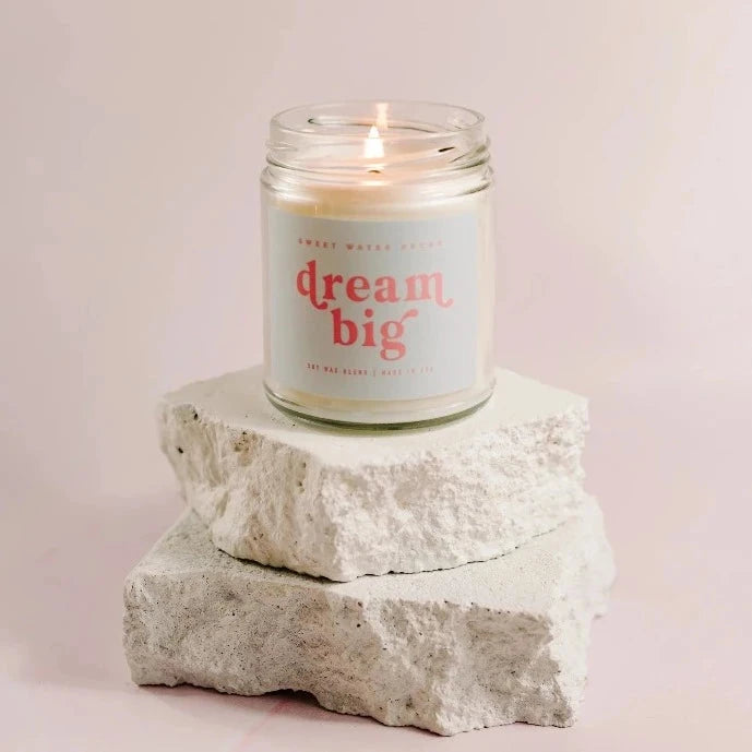Brennende Sojawachskerze Dream Big von Sweet Water Decor im Schraubglas steht auf 2 Steinplatten.