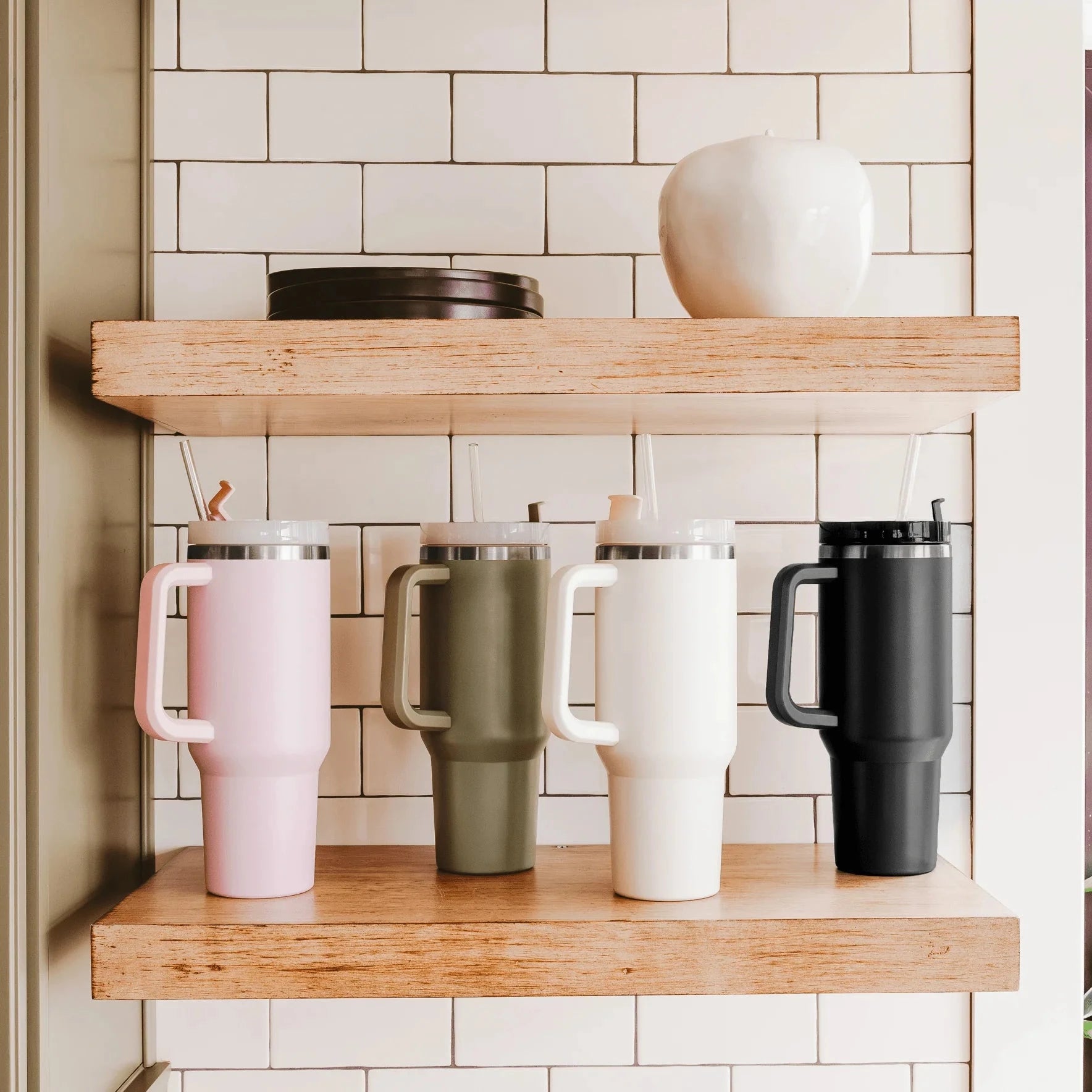 Tumbler / Thermobecher von Sweet Water Decor in 4 verschiedenen Farben, stehen nebeneinander in einem Regal.