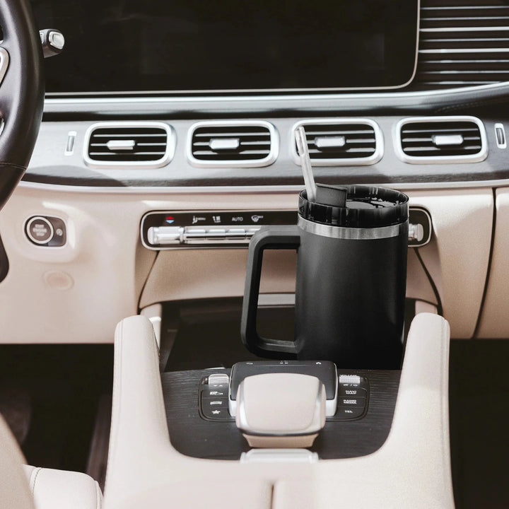 Schwarzer Tumbler / Thermobecher von Sweet Water Decor steht in der Mittelkonsole eines Autos.