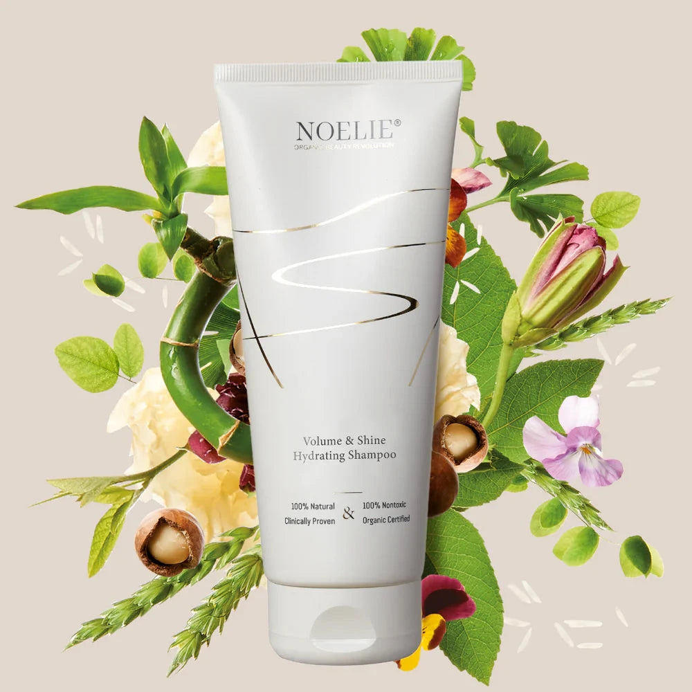 NOELIE Volume & Shine Shampoo, im Hintergrund verschiedene Blumen und Pflanzen.
