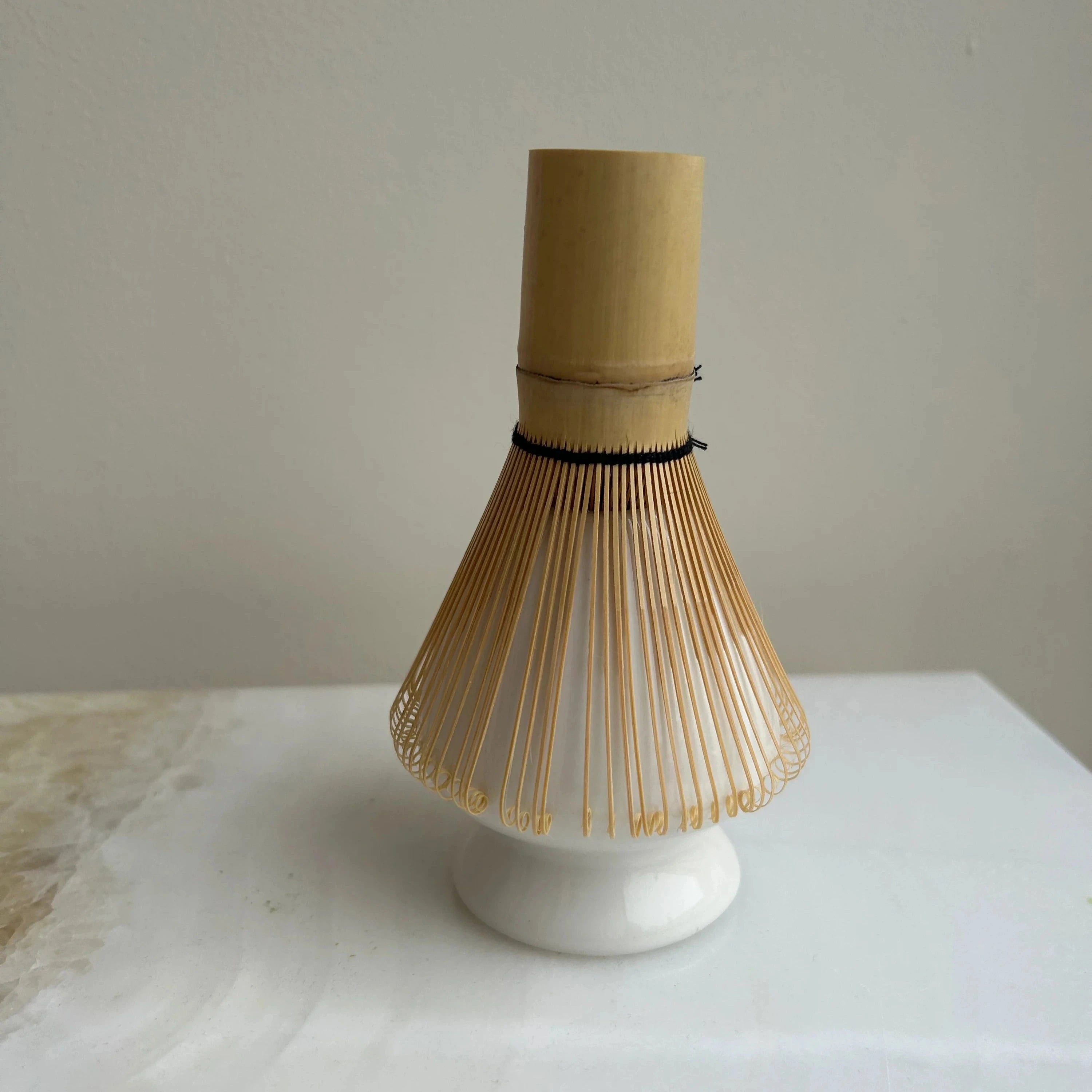 Matcha Besen - Halter CHASEN YASUME mit Matcha Besen stehend auf einem weißen Tisch.