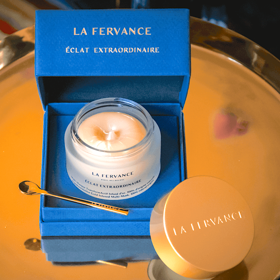 La Fervance Eclat Extraordinaire Tiegel in blauer Verpackung mit goldenem Spatel auf goldenem Teller North Glow