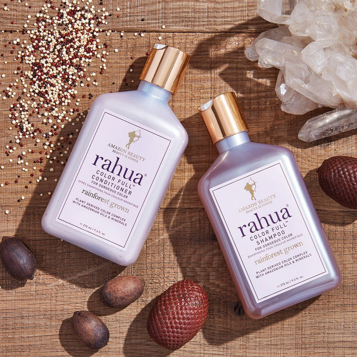 2 Flaschen Rahua Color Full Shampoo und Conditioner auf einem Holzuntergurnd dekoriert mit Quinoa, Rahuanüssen und Edelsteinen.