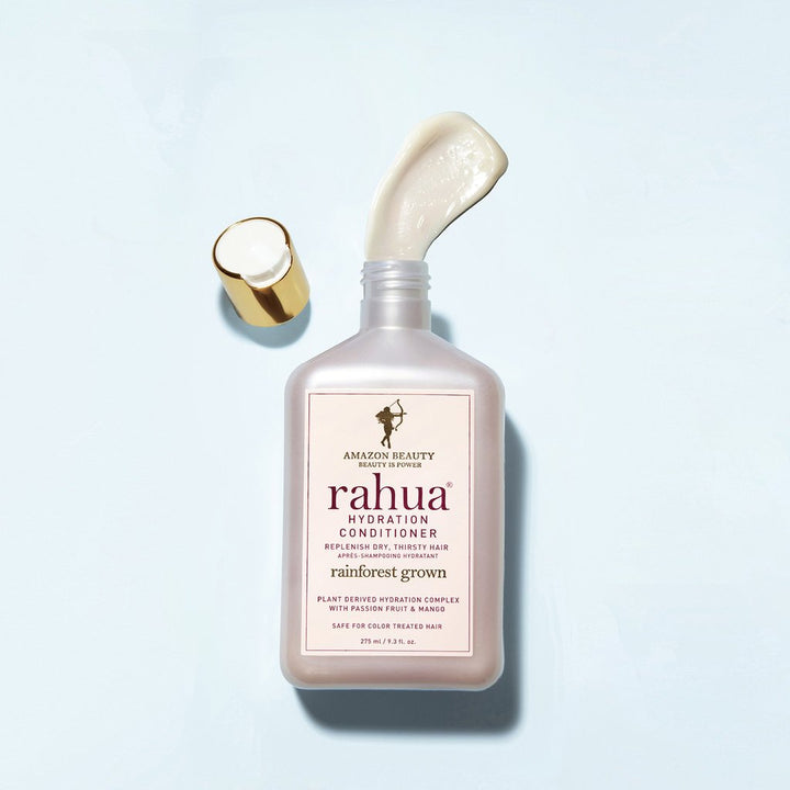 Offene Rahua Hydration Conditioner Flasche mit Texturbeispiel vor weißem Hintergrund.