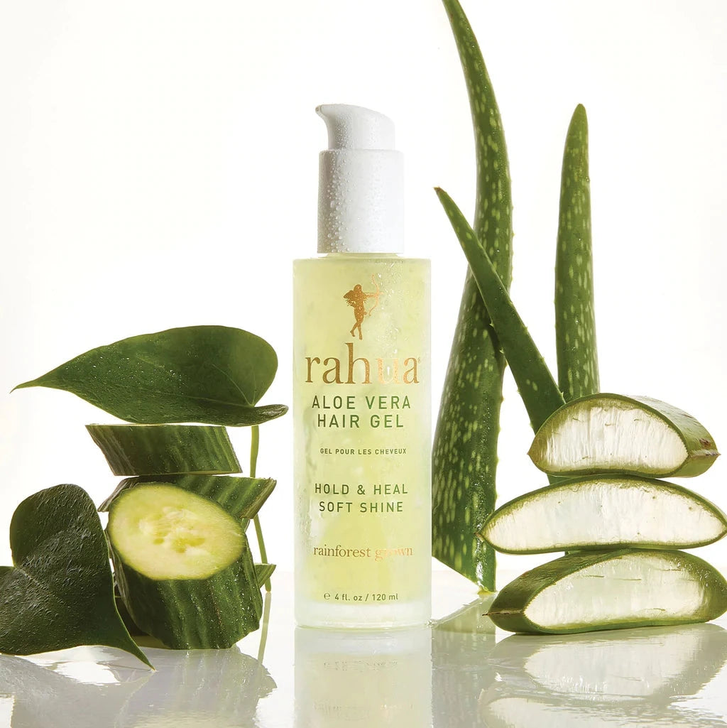 Rahua Aloe Vera Hair Gel Flasche steht zwischen aufgeschnittenen Aloeblättern und Gurken.