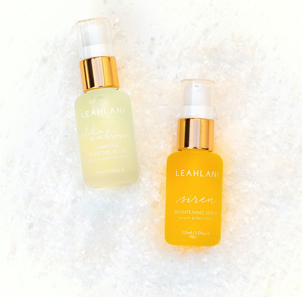 Leahlani Aloha Ambrosia Elixir und Siren Brightening Serum vor hellem Hintergrund Glasflasche