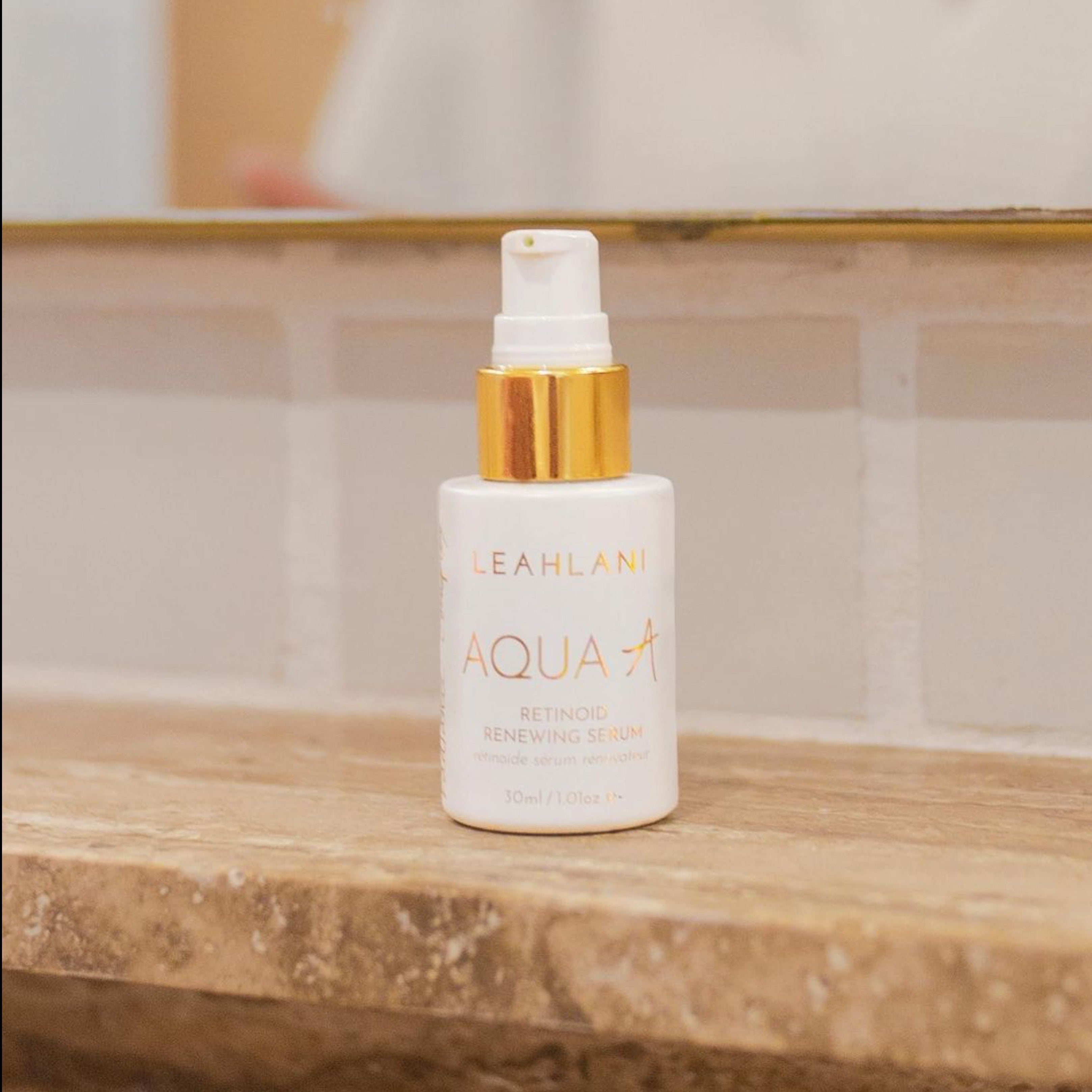 Leahlani Retinol AquaA weiße Flasche auf Holzbrett vor hellen Fliesen und Badspiegel