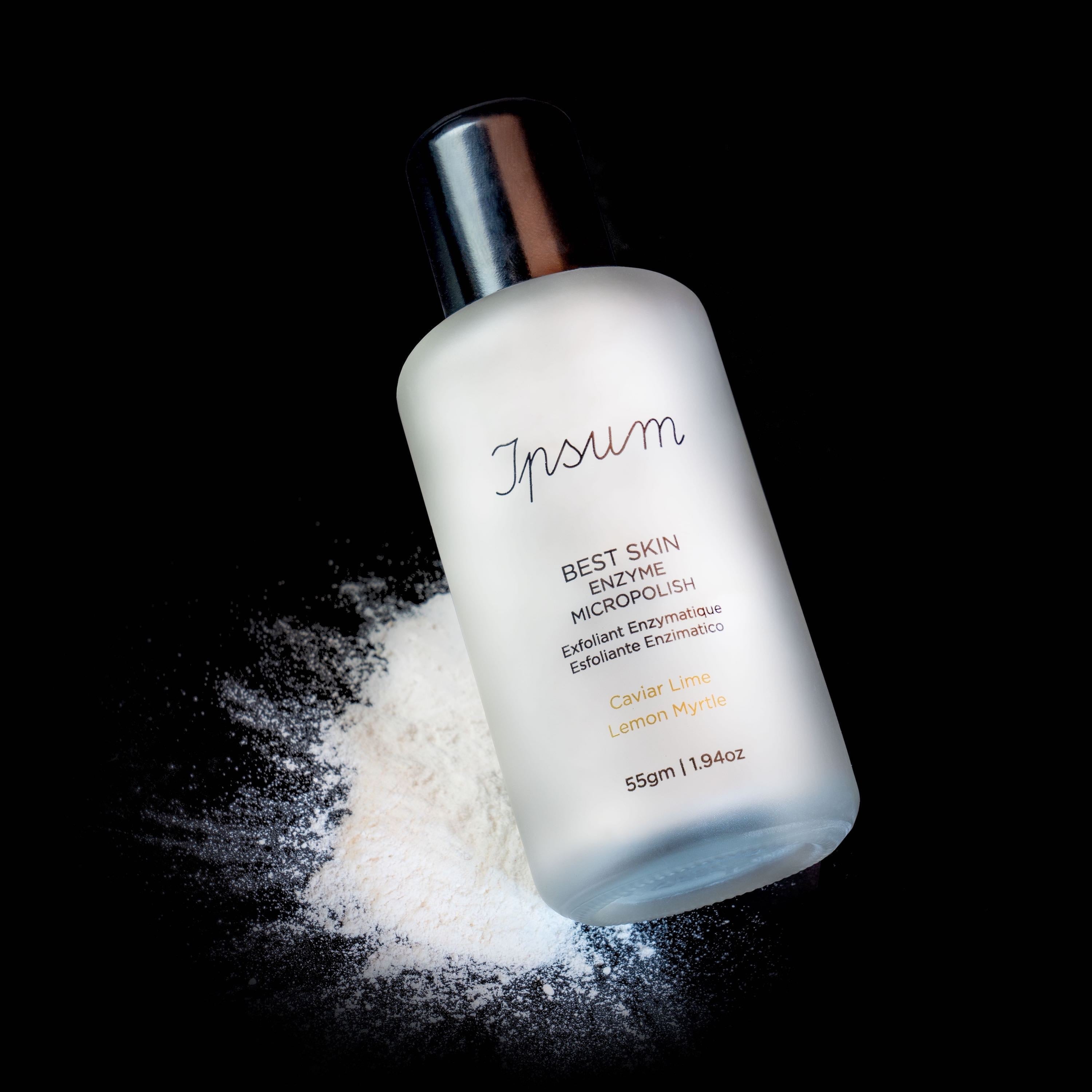 Ipsum Best Skin Enzyme MicroPolish Milchglasflasche mit schwarzem Deckel mit verstreutem Pulver vor schwarzem Hinergrund.