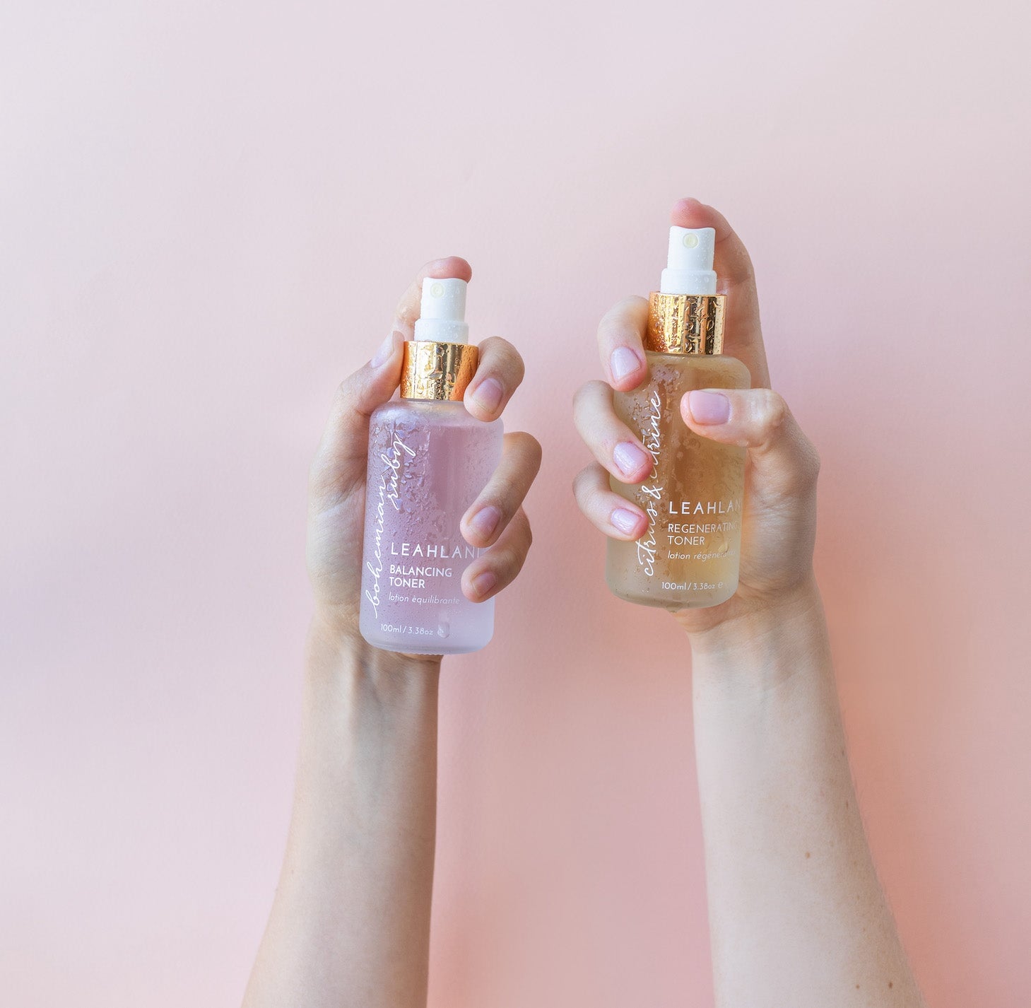 Frauen halten Leahlani Bohemian Ruby Toning Mist und Citrus und Citrine Toner in der Hand vor hellem Hintergrund