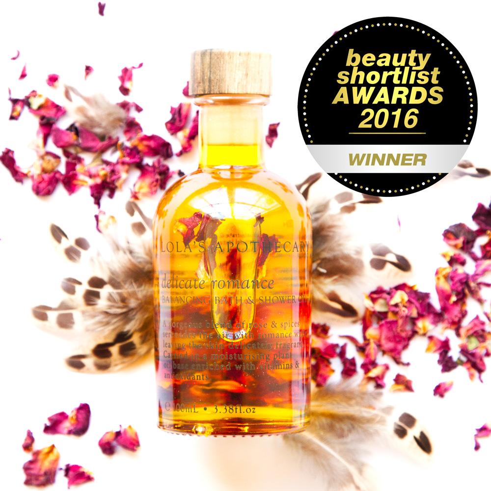 Lola´s Apothecary Delicate Bath & Shower Oil Flakon vor Rosenblättern und Federn North Glow