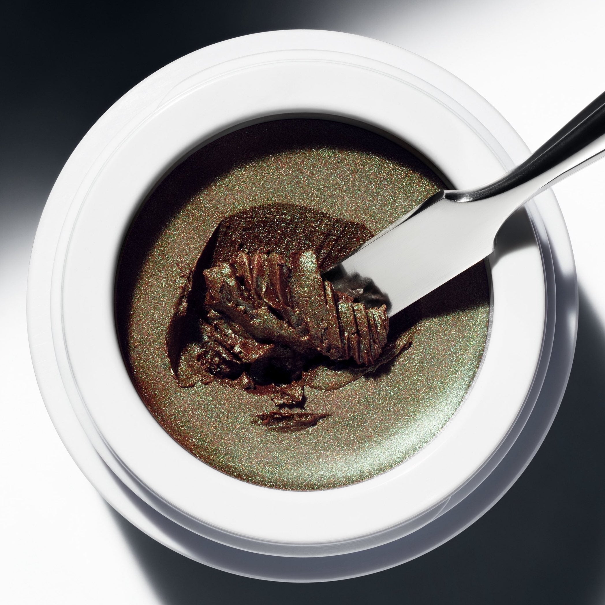 Offener Eye Glow Colour Tiegel Ochaya aus der Vogelperspektive steht auf weißem Untergrund.