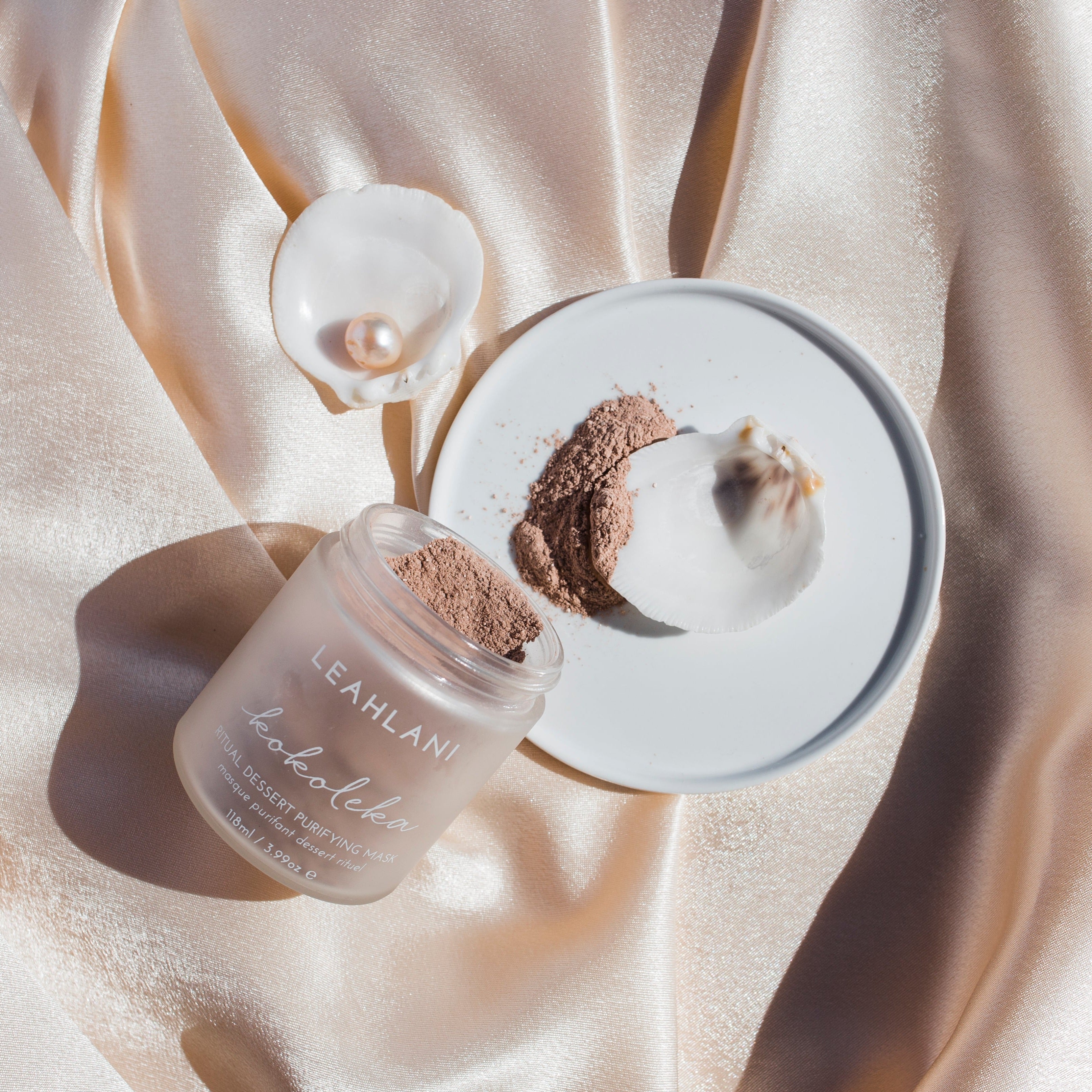 Leahlani_Kokoleka_Heilerde Maske geöffnet auf heller Decke mit Muscheln und Perle