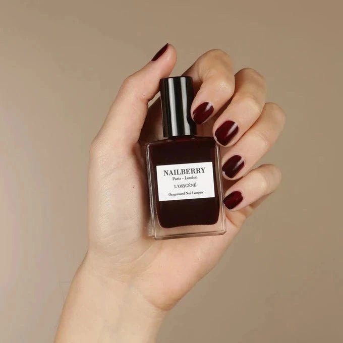 Hand hält Nailberry Nagellackflasche Noirberry.