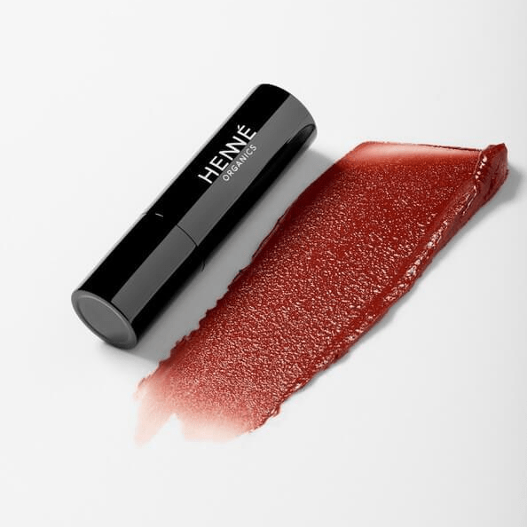 Schwarzer Lippenstift mit Farb- und Texturbeispiel der Farbe Intrigue von Henné Organics.