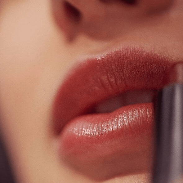 Lippenstift der Farbe Intrigue von Henné Organics auf Lippen aufgetragen.
