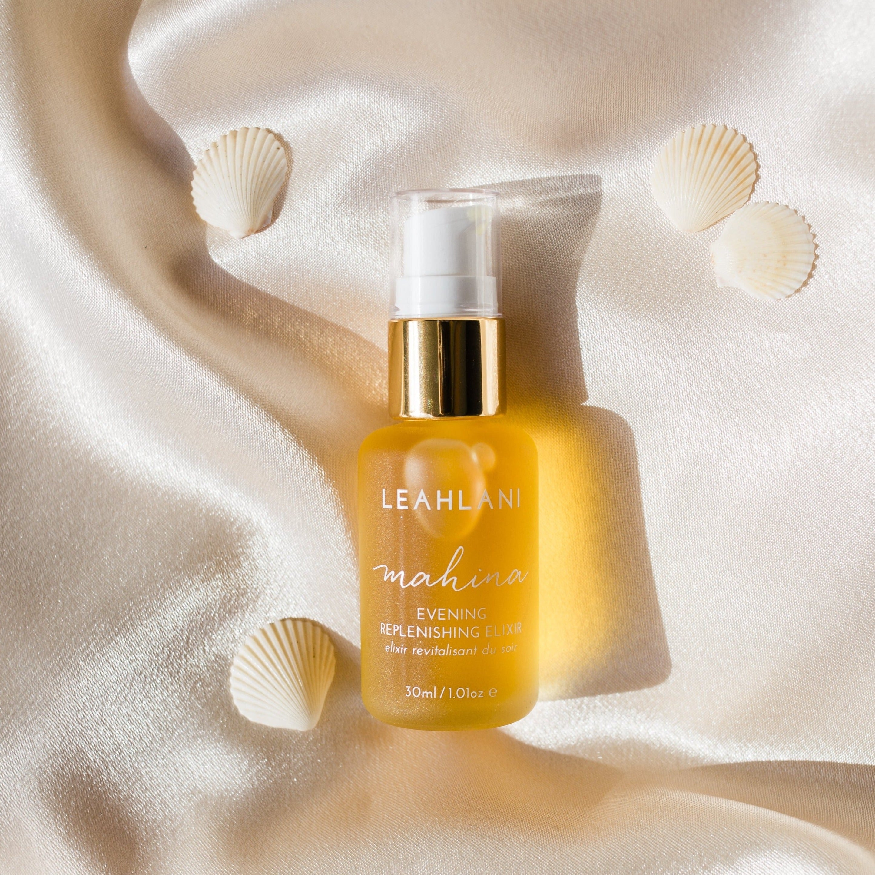 Leahlani Mahina Evening Elixir Flakon mit Muscheln auf perlmuttfarbener Decke