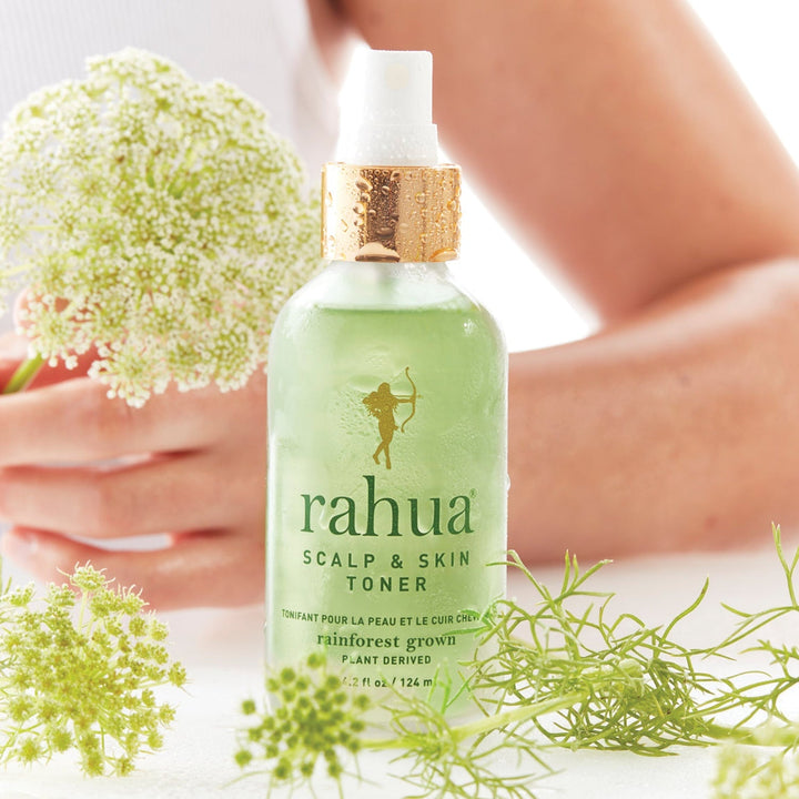 Rahua Scalp & Skin Toner Flasche vor der Silhouette einer Frau dekoriert mit weißen Blumen.