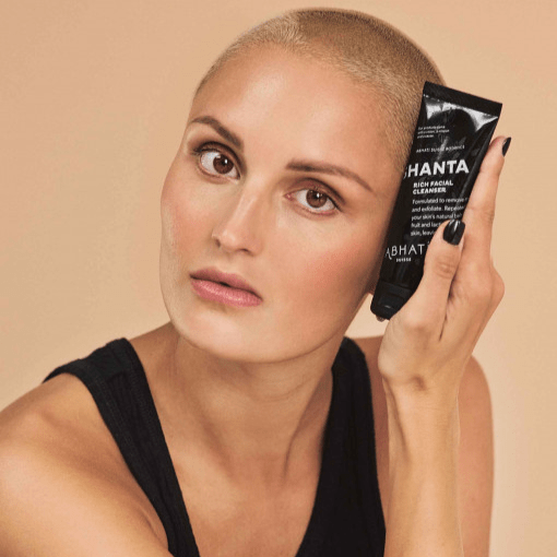 Eine Frau mit kurzem Haar hält eine Abhati Suisse Shanta Tube in der Hand gegen ihren Kopf.