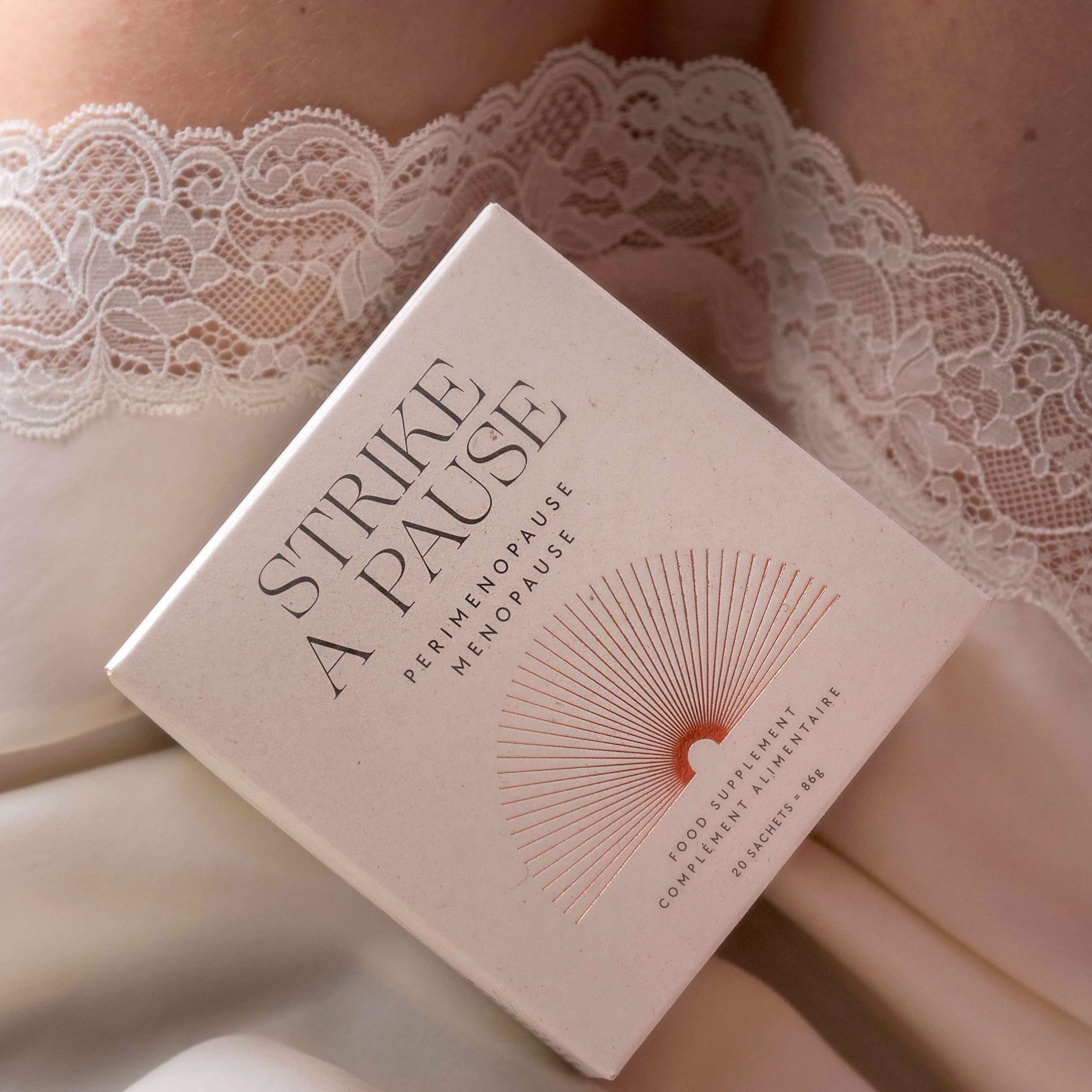 Depuravita Strike A Pause Verpackung auf weiblichem Schoß mit Spitzennachthemd