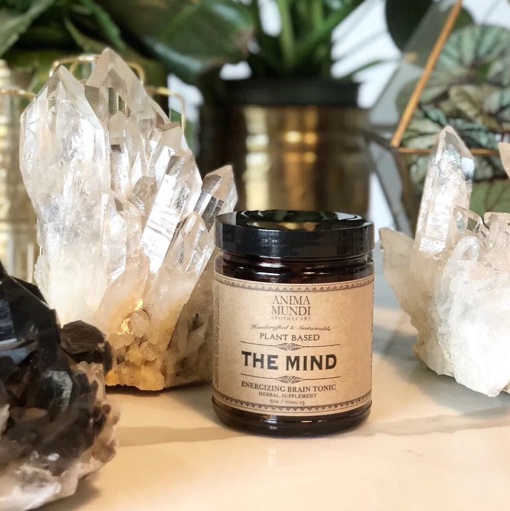 Anima Mundi The Mind Schraubglas steht zwischen großen Kristallen.