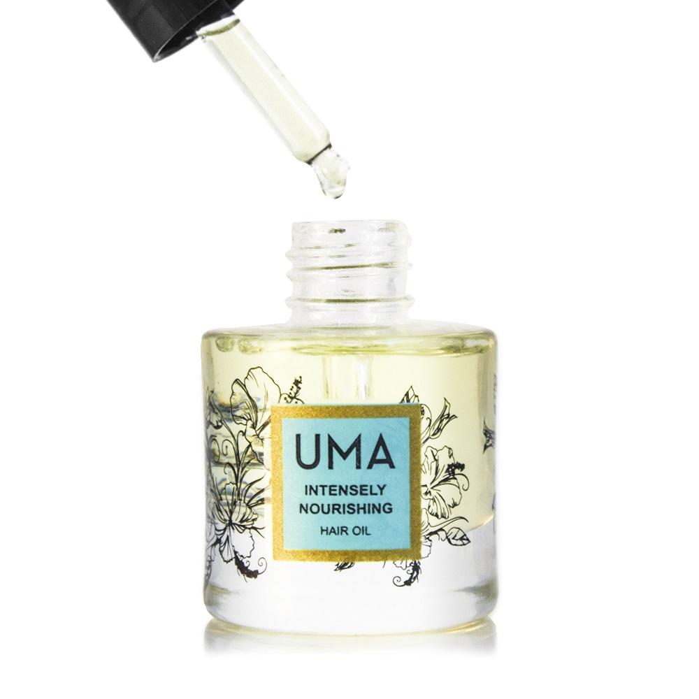 Eine gefüllte Pipette mit dem UMA Intensely Nourishing Hair Oil schwebt über der offenen Flasche, die vor weißem Hintergrund steht. 