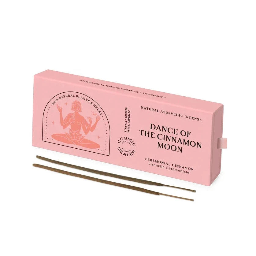 Cosmic Dealer Räcuherstäbchen "Dance of the cinnamon moon" Verpackung und mit zwei Räucherstäbchen liegend im Vordergrund, vor weißem Hintergrund. North Glow