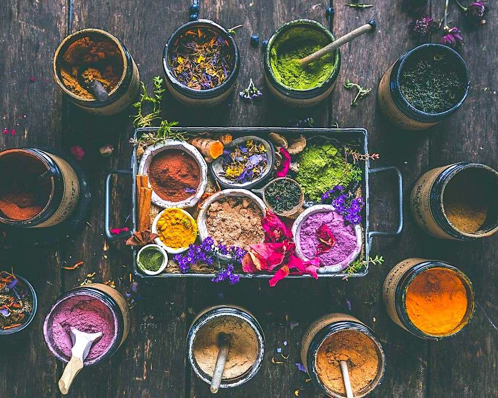 Offene Anima Mundi Herbalgläser mit Pulvern in kräftigen Farben aus der Vogelperspektive.