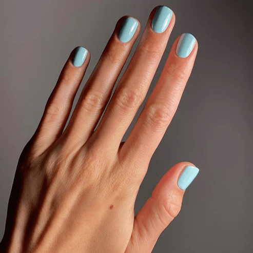 Gepflegte Hand mit sanft nebligen, blauen Nagellack von Karolin Van Loon – Farbton Brume Océane 