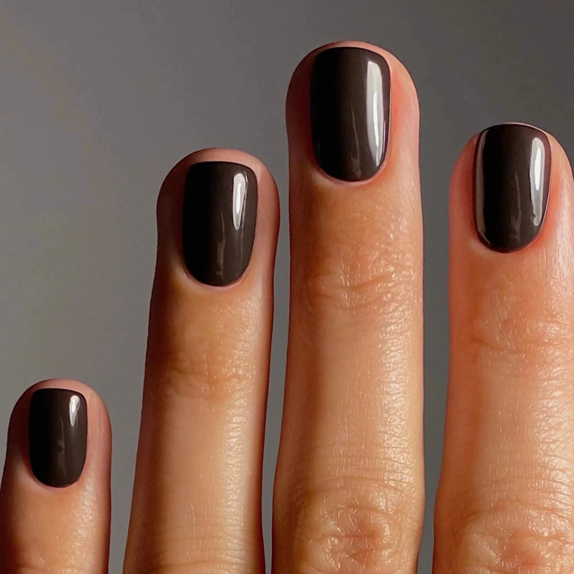 Karolin Van Loon 54 Figue Marron veganer brauner Nagellack mit goldenen Untertönen auf Fingernägeln.